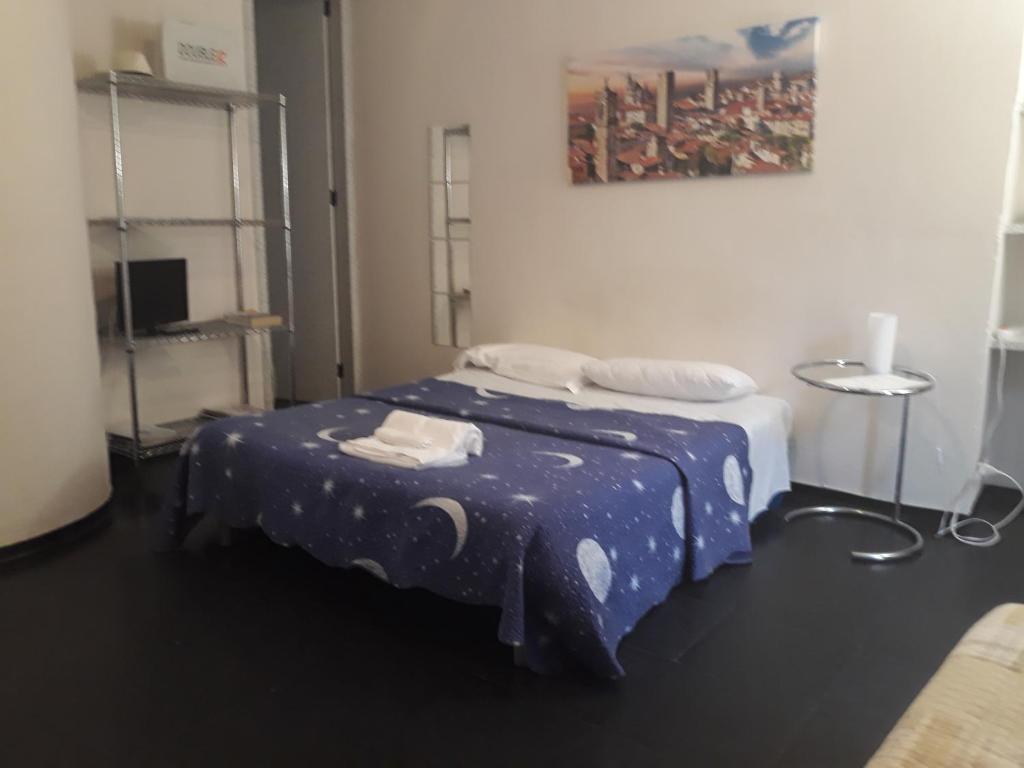 een slaapkamer met een bed met een blauw dekbed bij Romeo and Juliet Apartaments in Bergamo