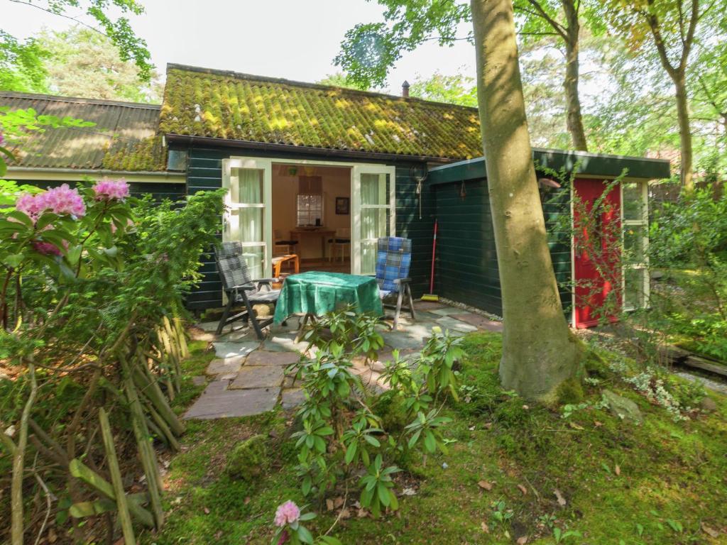 ein kleines Haus mit einem Tisch und Stühlen im Hof in der Unterkunft In the middle of the Gooise landscape in Huizen