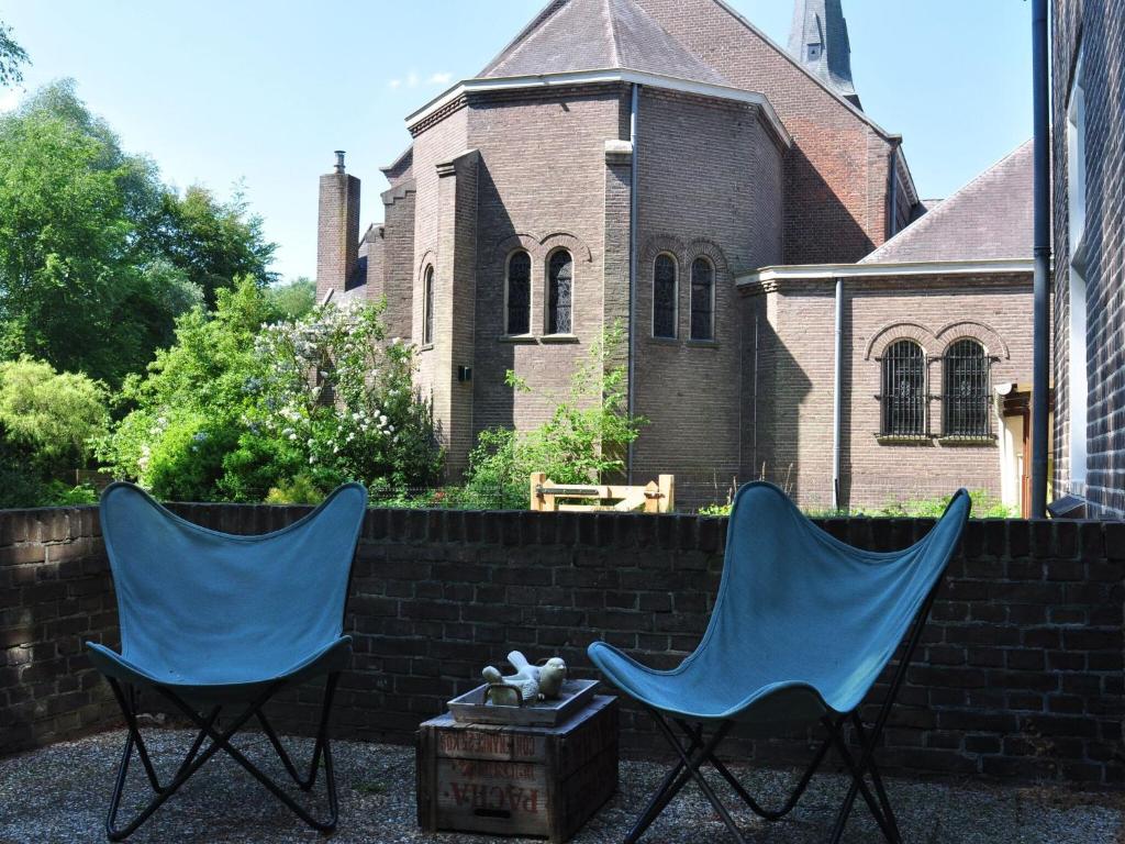 deux chaises bleues assises devant un bâtiment dans l'établissement Modern Villa near Forest in Leende, à Schaft
