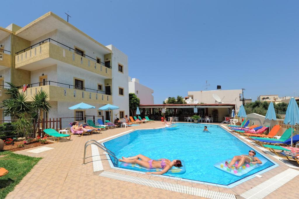 a group of people swimming in a pool at a hotel at Stelios Residence Apartments in Malia