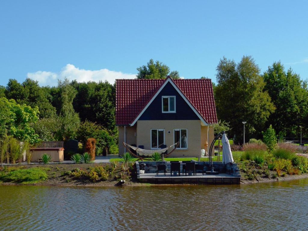 una pequeña casa con un barco en el agua en Spacious Holiday Home with Swimming Pool near Sea in Vodnjan, en Westerbork