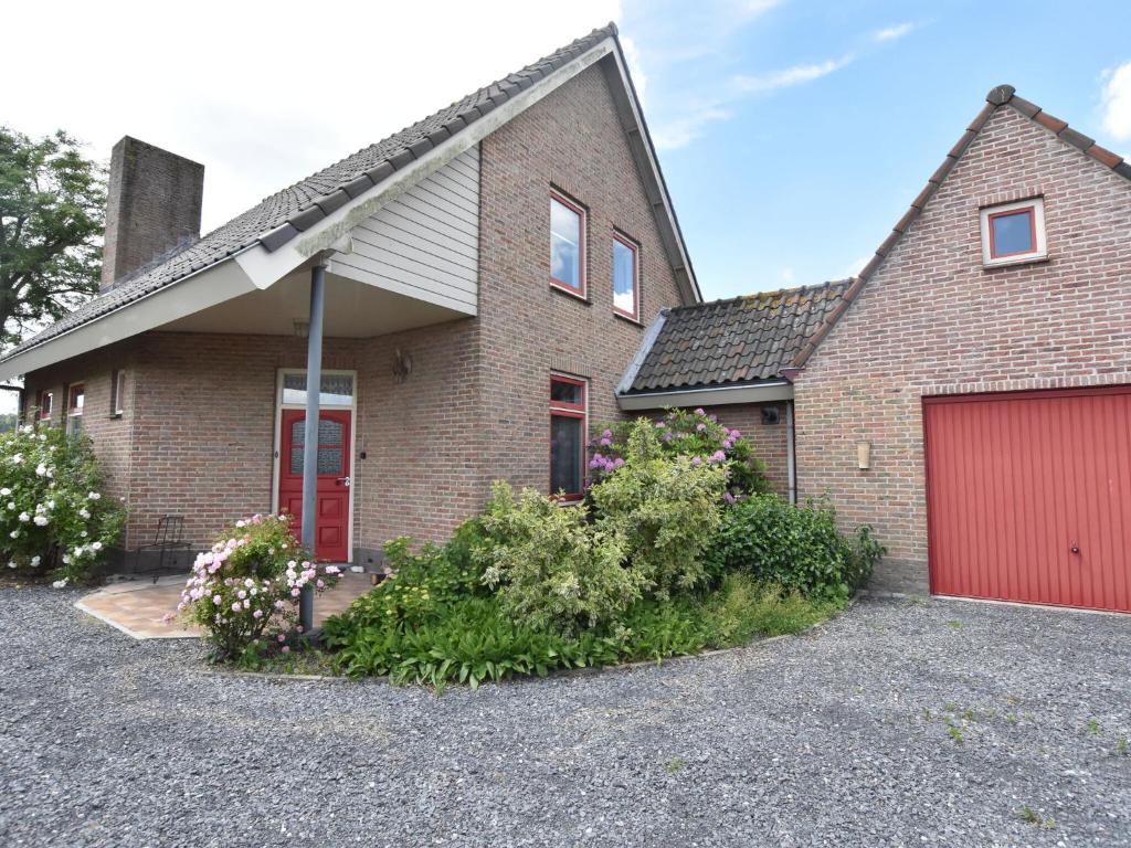 een stenen huis met een rode garage bij Beautiful Holiday Home in Eede with Garden in Eede