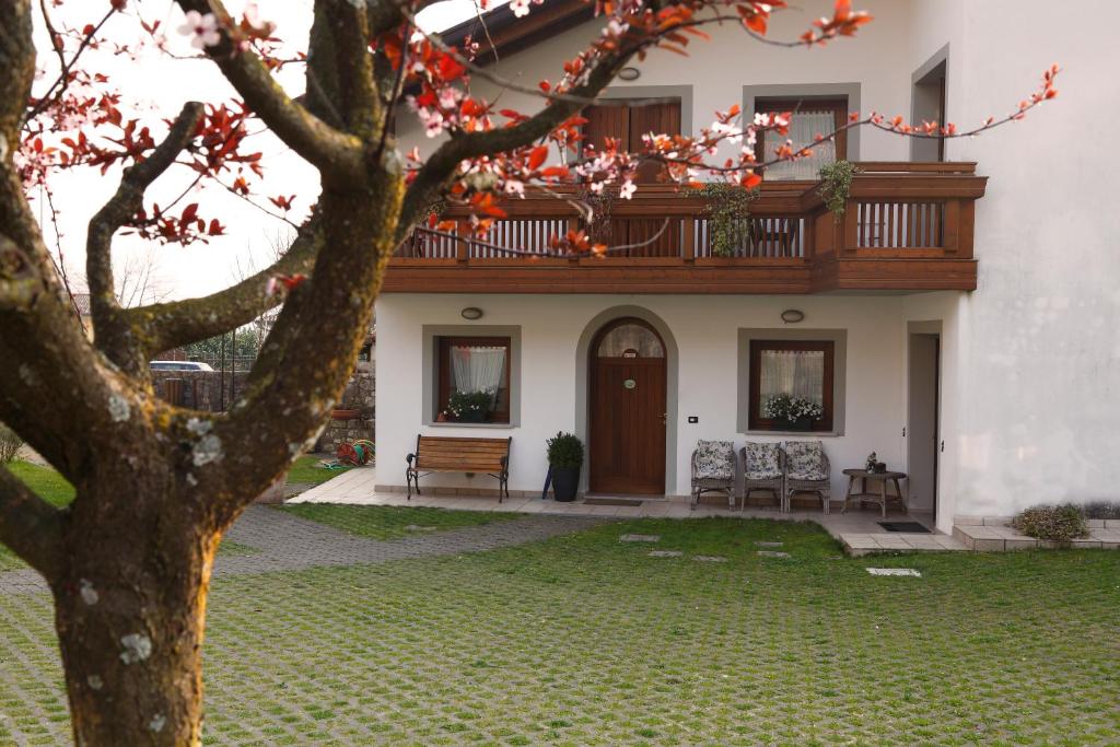 uma casa com varanda e uma árvore em Sentiero Valinis em Fanna