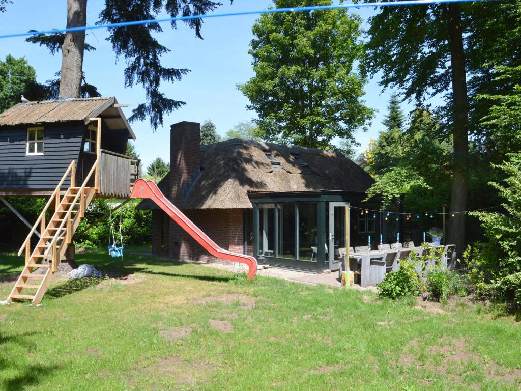 een huis met een speeltuin voor een gebouw bij Holiday home in Haaren near the Efteling in Haaren