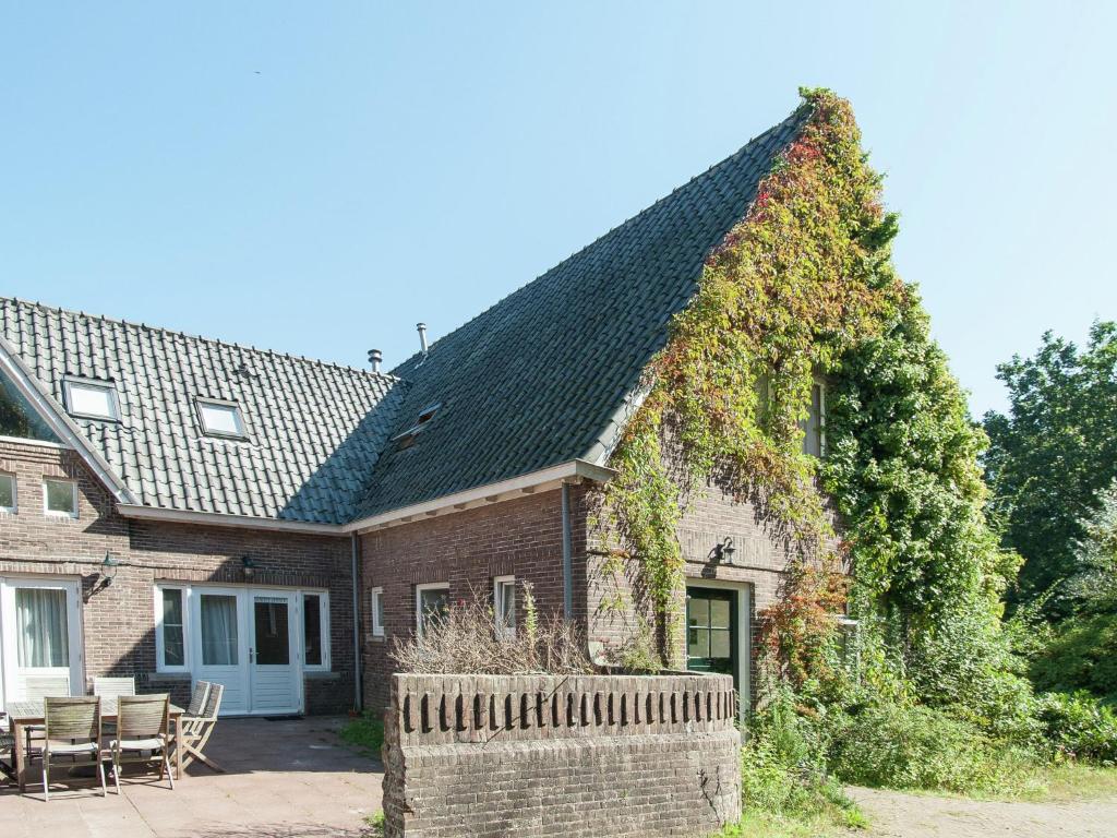 a brick house with an ivy covered roof at Holiday Home in Bergen aan zee with Terrace in Bergen aan Zee