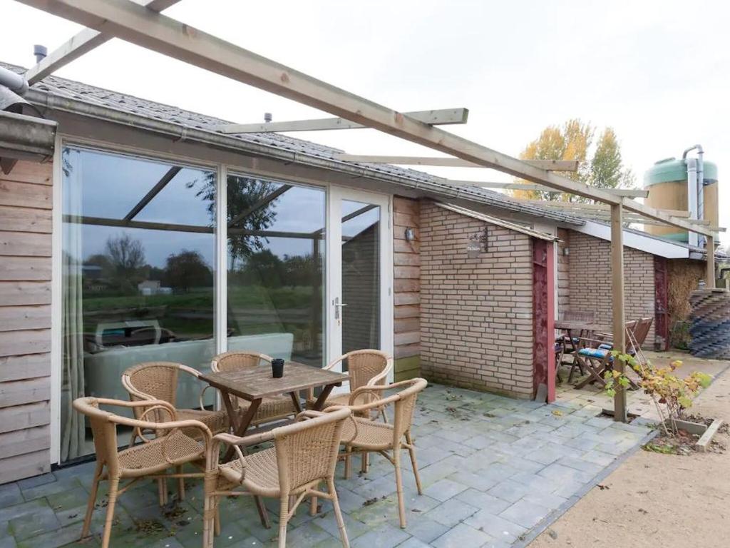 een patio met een houten tafel en stoelen bij Nice Holiday Home in Horssen at the Farmer with a Garden in Horssen