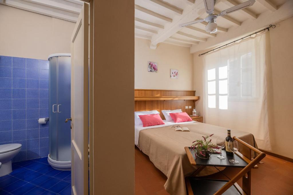 sypialnia z łóżkiem i łazienką z toaletą w obiekcie B&B San Francesco w mieście Cortona