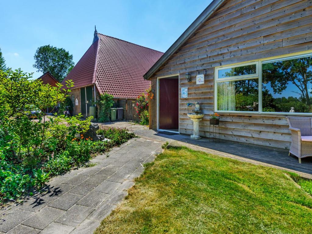 a house with a bench in the front yard at Farmhouse in Eastermar near De Leijen River in Hoogzand