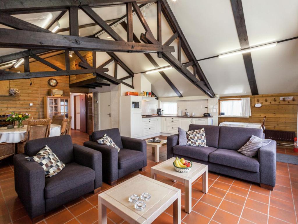 uma sala de estar com dois sofás e uma cozinha em Cozy Holiday Home in Oisterwijk with Swimming Pool em Oisterwijk