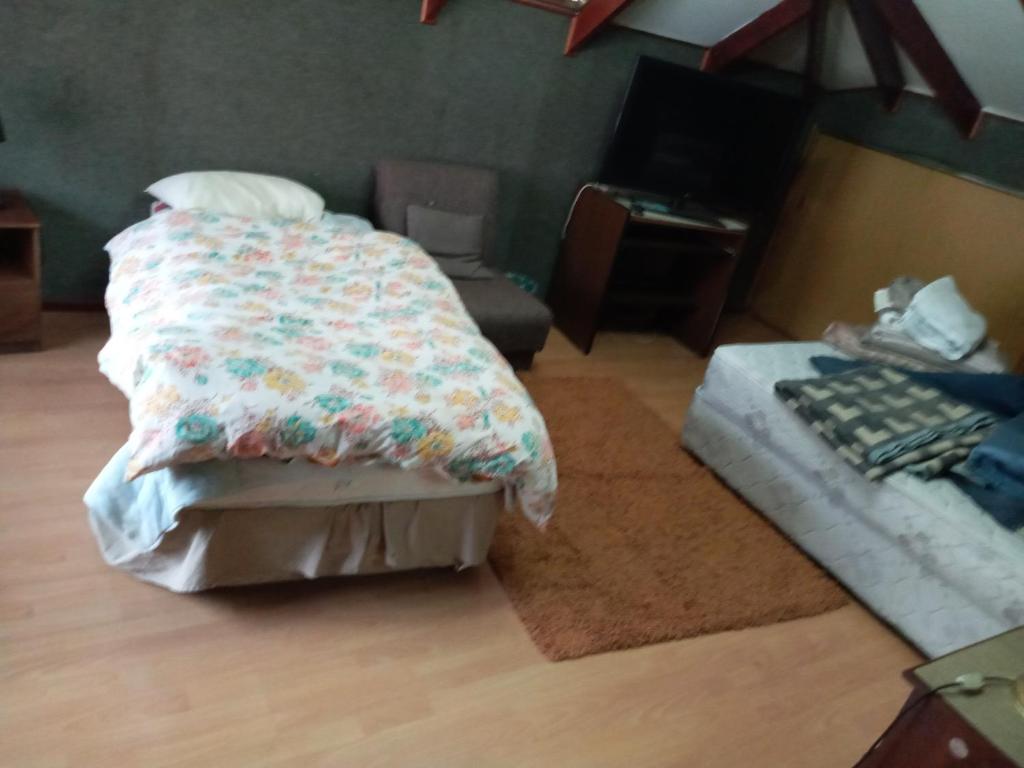 - une chambre avec un lit et un canapé dans l'établissement Hospedaje familiar Gloria, à Punta Arenas
