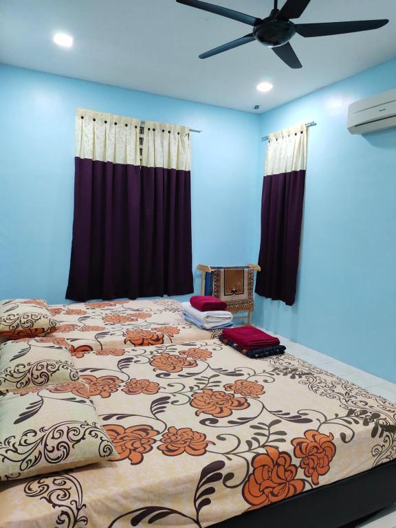 een slaapkamer met een groot bed met een bloemmotief bij Hazim Homestay Pakej 1 in Changlun