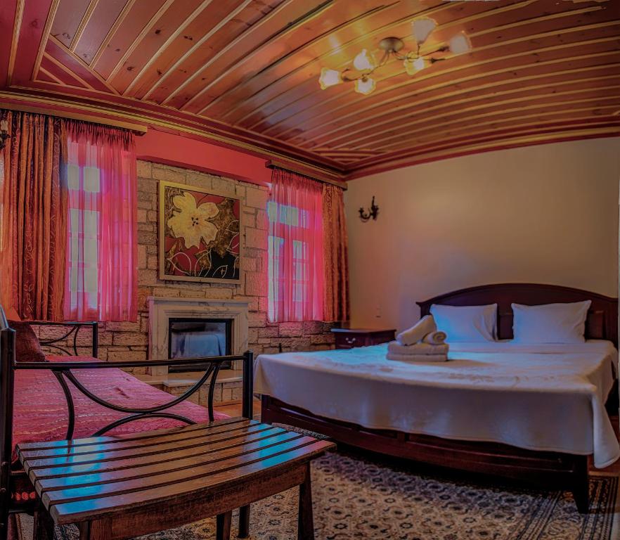 ein Schlafzimmer mit einem großen Bett und einem Kamin in der Unterkunft Aggelon Katafygio in Asprangeloi