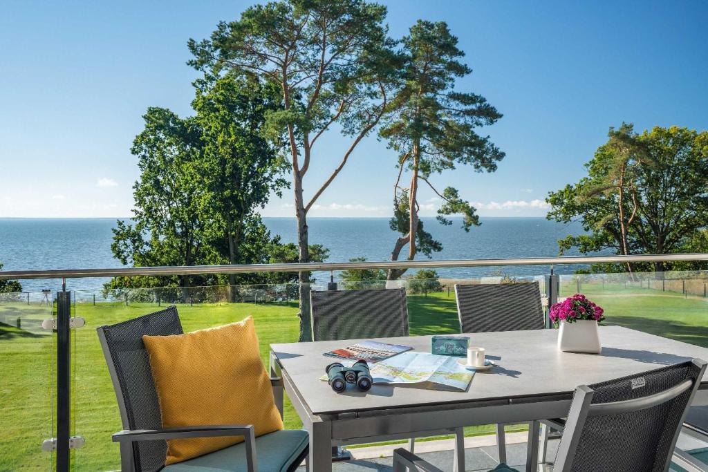 a table and chairs on a balcony with a view of the ocean at Appartement "Haffglück" mit Penthouseflair - Oase am Haff in Garz