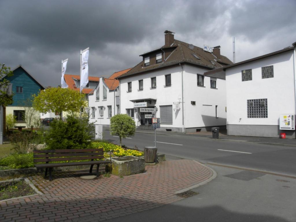 een straat met witte gebouwen en een bank in een straat bij Thüringer Hof in Richelsdorf