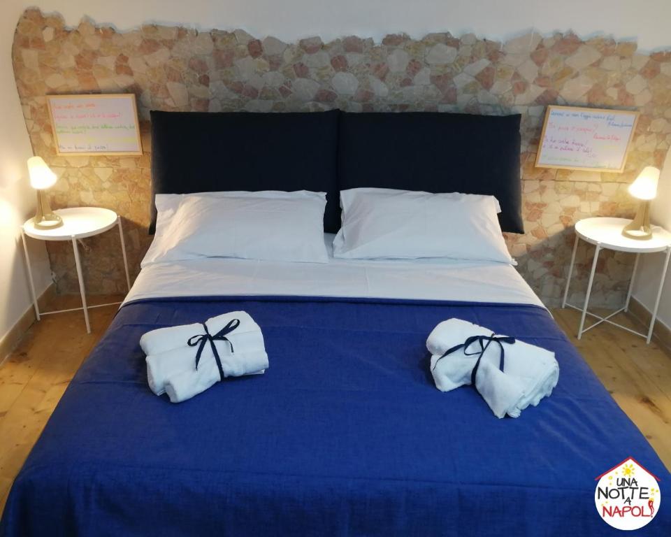 Una cama con dos toallas y dos mesas. en Una Notte a Napoli, en Nápoles