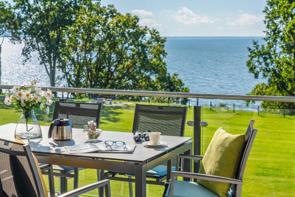 a table and chairs on a balcony with the ocean at Appartement "Mondstein" mit Penthouseflair - Oase am Haff in Garz-Usedom