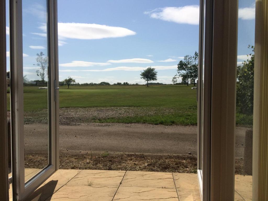 una puerta abierta con vistas a un campo en Hilltop Cottage en Dursley