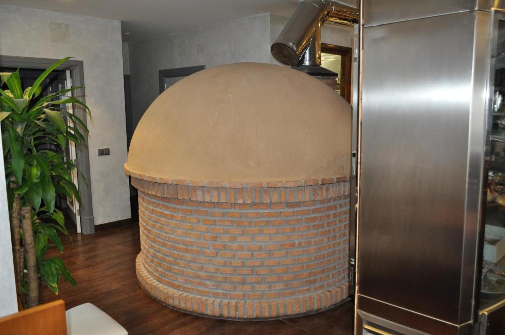 dużą beczkę siedzącą na podłodze obok lodówki w obiekcie Hotel El Volao w mieście Villanueva de Córdoba
