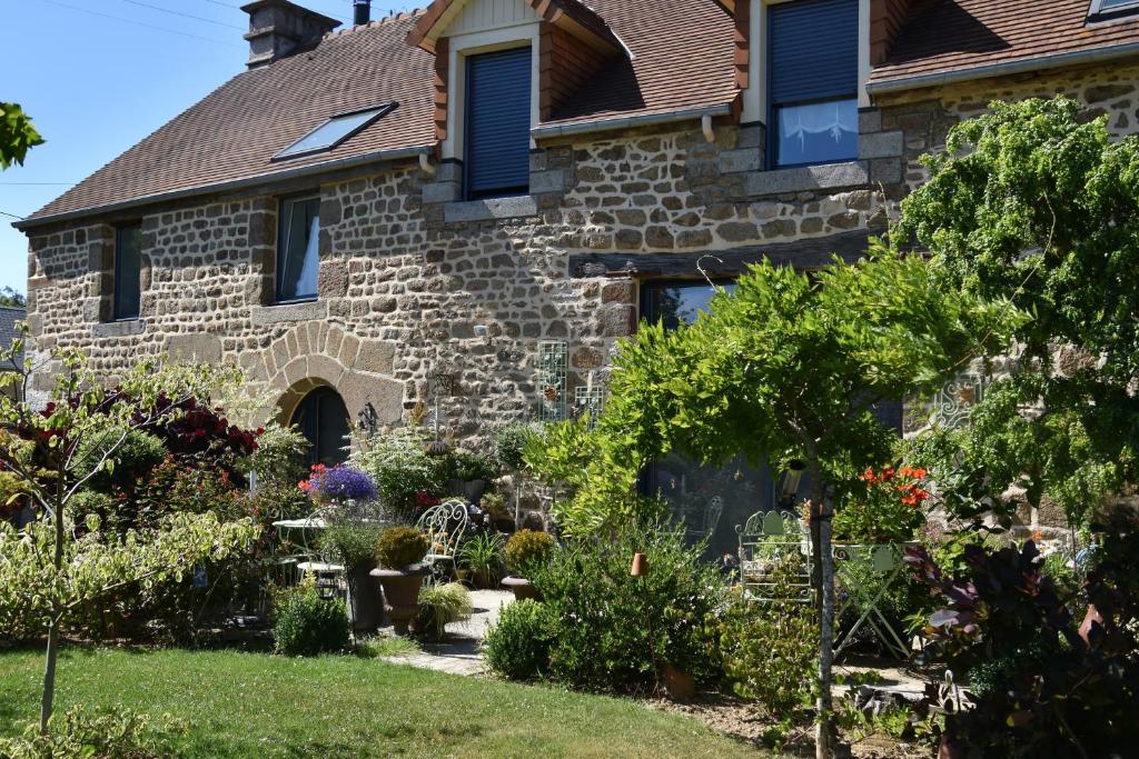 a stone house with a garden in front of it at La Grange Bagnolaise in Bagnoles de l'Orne