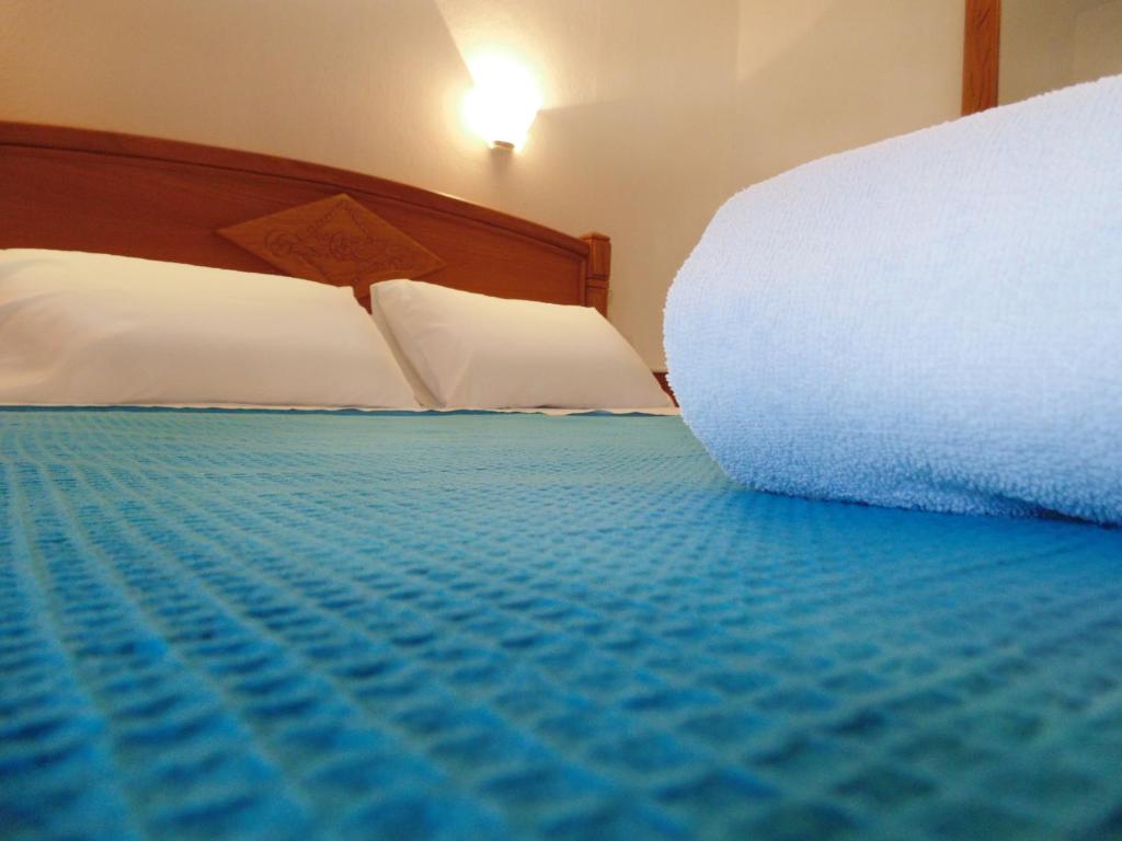 1 dormitorio con cama con almohadas blancas y colcha azul en Villa Melini en Patitírion