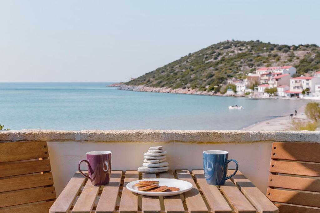 stół z talerzem jedzenia na balkonie z widokiem na plażę w obiekcie SeaView Apartment & Studio w mieście Psili Ammos