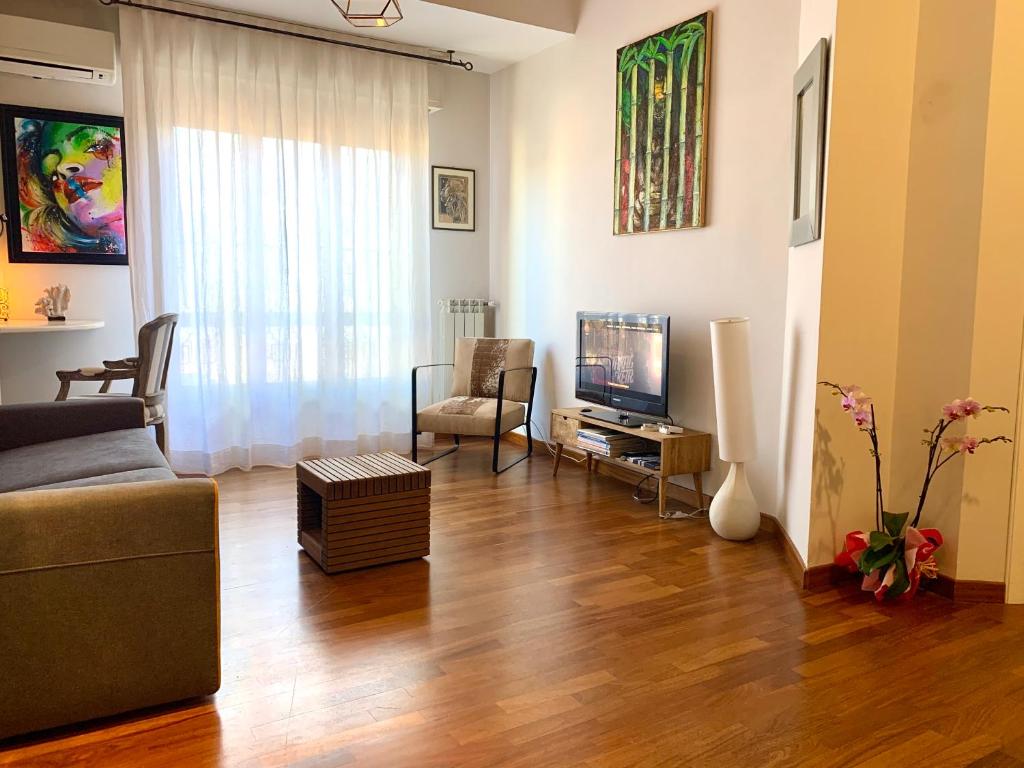 salon z kanapą i telewizorem w obiekcie Monkey w mieście Reggio di Calabria