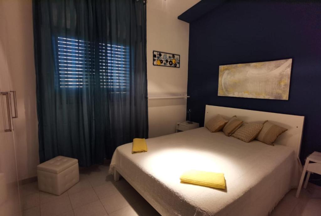 a bedroom with a bed with a blue wall at appartamento dei colori anticaglie in Punta Secca