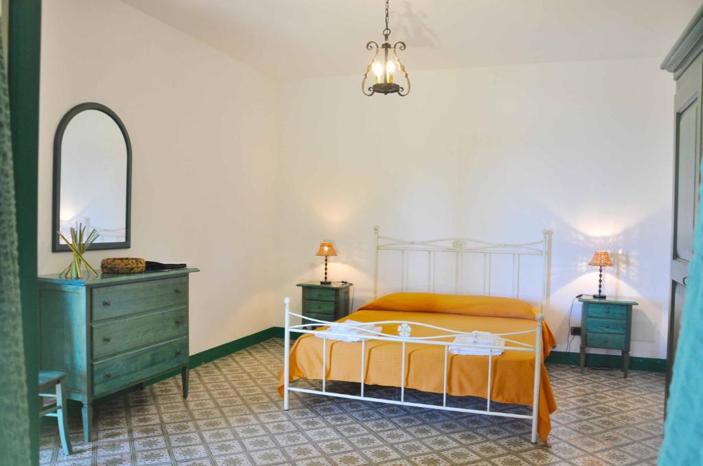una camera con letto, cassettiera e specchio di Le Mànnare Case Vacanze di Metopa srl a Piano Conte