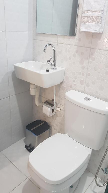 uma casa de banho branca com um WC e um lavatório em Paraíso do Boldró Flat em Fernando de Noronha