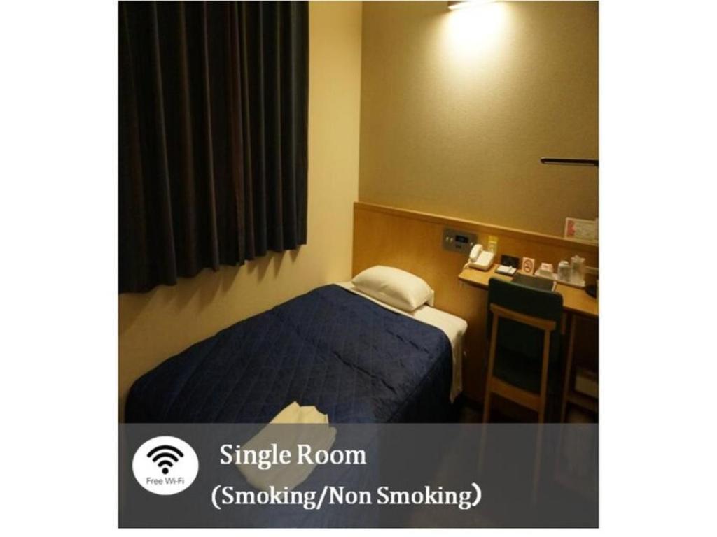 ein Hotelzimmer mit einem Bett und einem Schreibtisch in der Unterkunft Plaza Arakawaoki - Vacation STAY 24679v in Tsuchiura