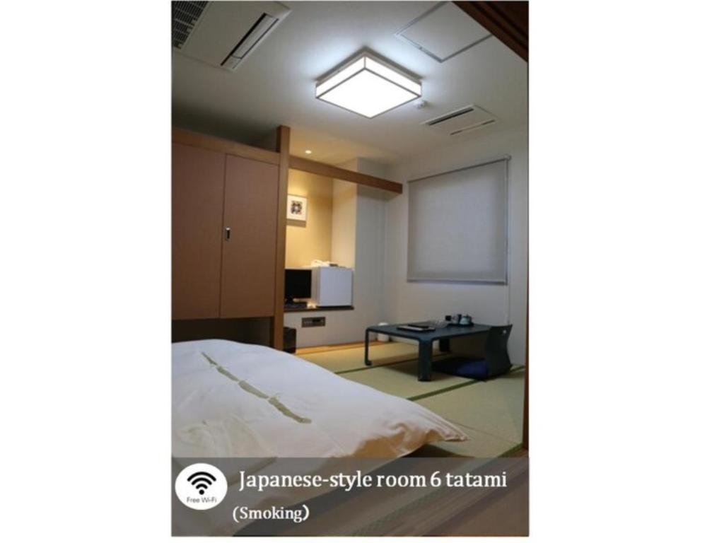 Habitación con cama, pantalla de proyector y mesa. en Plaza Arakawaoki - Vacation STAY 24681v, en Tsuchiura