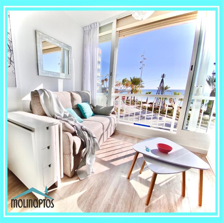 a living room with a couch and a view of the ocean at Estudio 32 Frente al Mar by Molinaptos in Benidorm