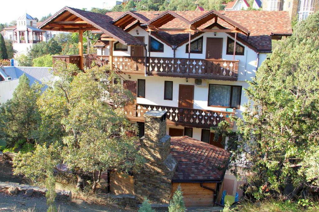 une maison entourée d'une terrasse couverte. dans l'établissement Shaliapin House, à Novyï Svet