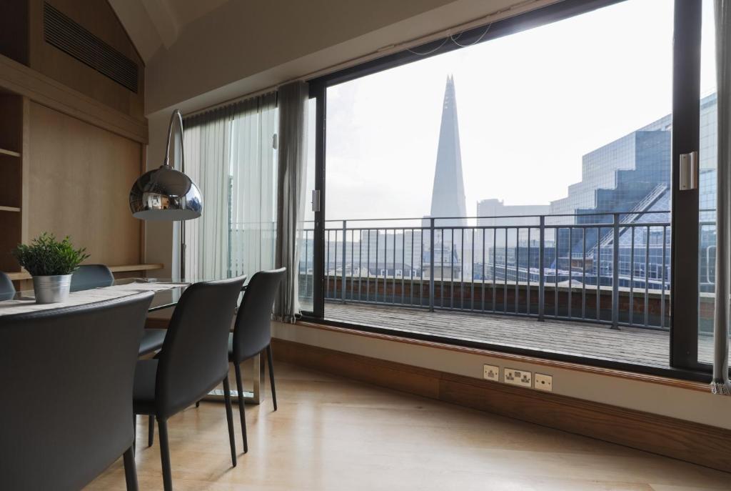 a dining room with a large window with a view of the city at Monument by Excel Apartments in London