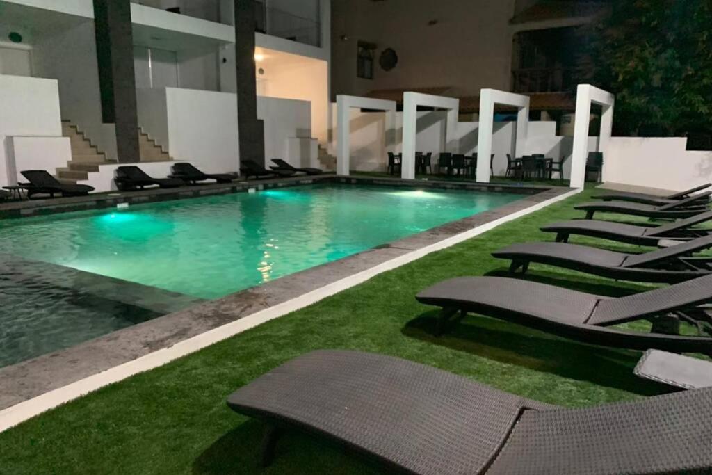 a swimming pool with lounge chairs in a building at Departamento Topacio 2 Joyas del mar San Carlos in San Carlos