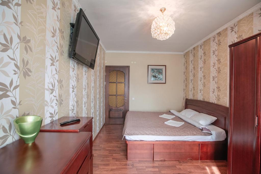 a small bedroom with a bed and a tv at Welcome Home Apartments Baikalskaya 107 in Irkutsk