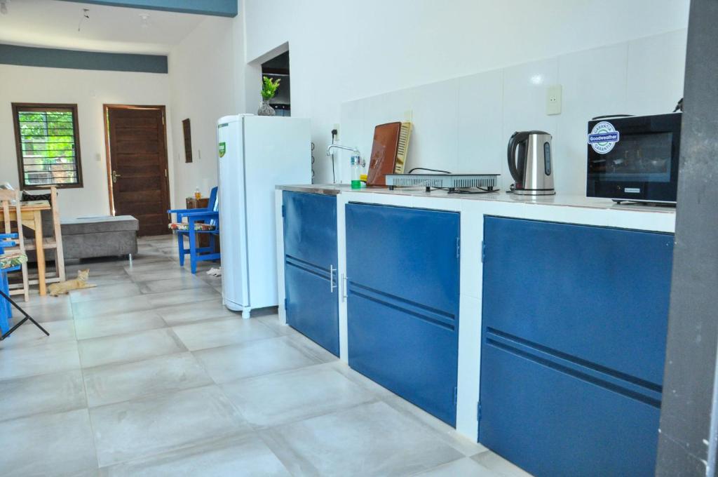 La cuisine est équipée de placards bleus et d'un réfrigérateur blanc. dans l'établissement CASA Naranja.RR, à Barrio San Isidro (2)