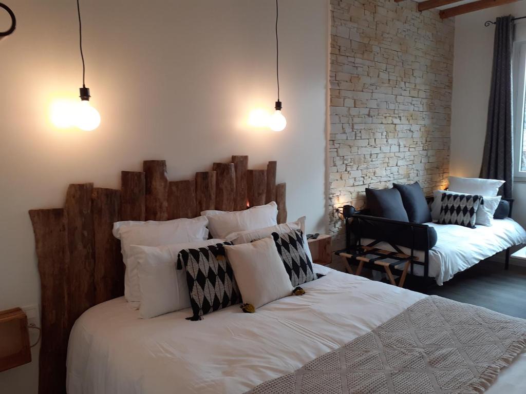 una camera con un grande letto con testiera in legno di CHARMES EN VILLE Le Charme Atypique a Montluçon