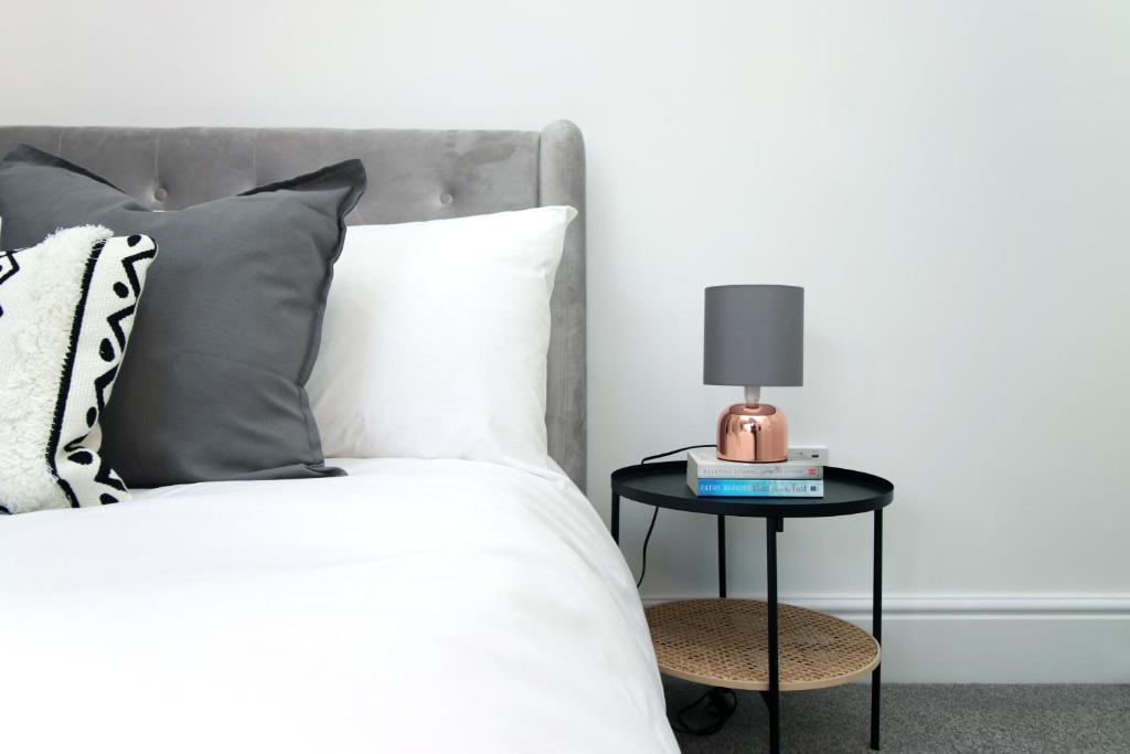 a bedroom with a bed with a side table with a lamp at Eveswell Studios in Newport