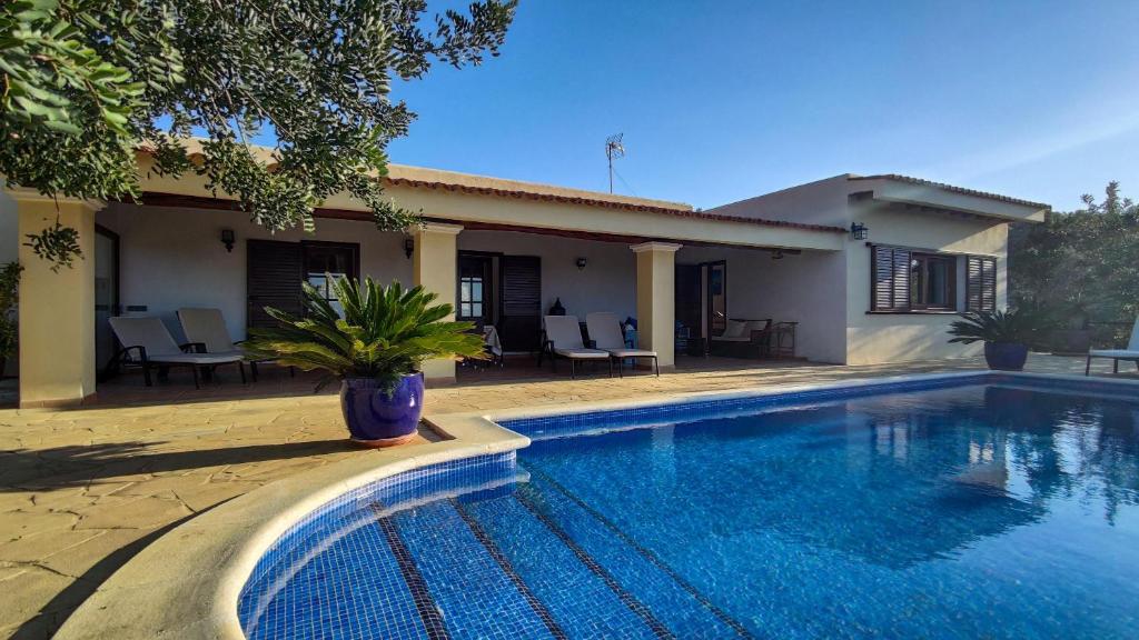 a villa with a swimming pool in front of a house at Casa Ibicenca Con Piscina Privada in San Jose