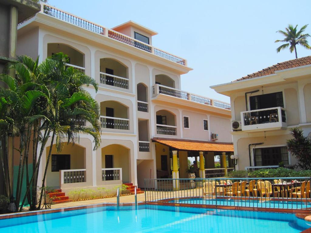 un hôtel avec une piscine en face d'un bâtiment dans l'établissement Riverside Regency Resort, à Baga