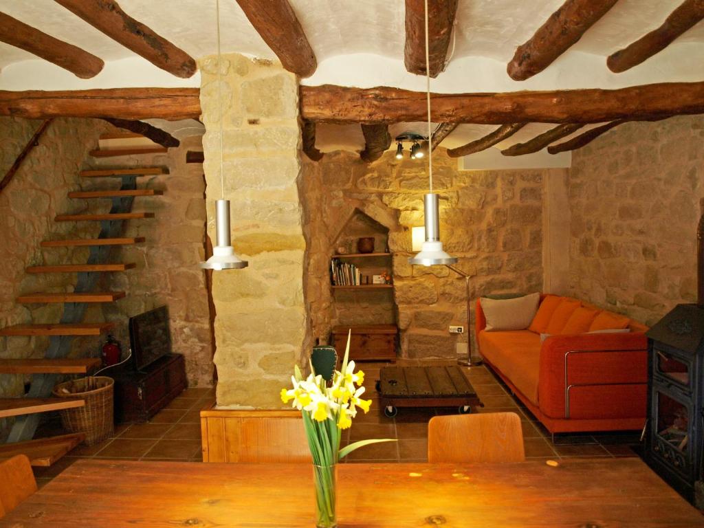 a living room with a couch and a table with flowers at Alojamiento La Fresneda in La Fresneda