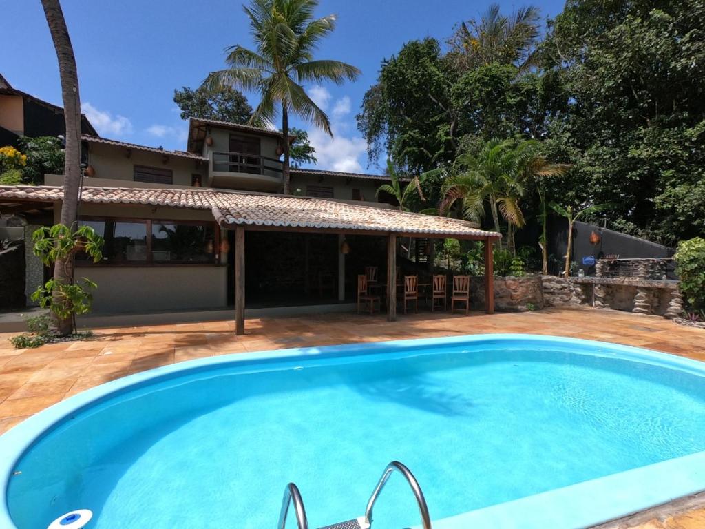 a swimming pool in front of a house at Hostel La Isla in Pipa