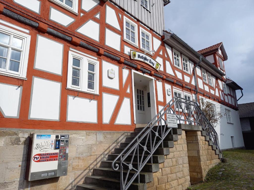 a half timbered house with a staircase leading up to it at Wollröder Krug in Guxhagen