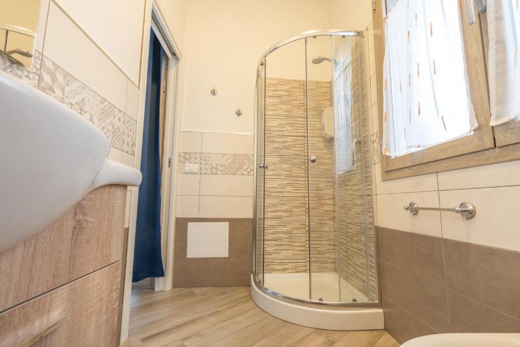 bagno con doccia e lavandino di DOMOBLU Camere In Centro a Tortolì