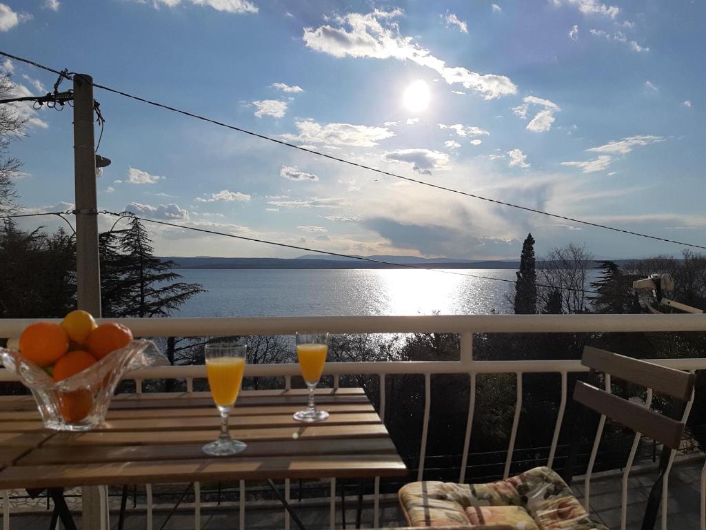 a table with two glasses of orange juice on a balcony at Apartment Elena in Dramalj