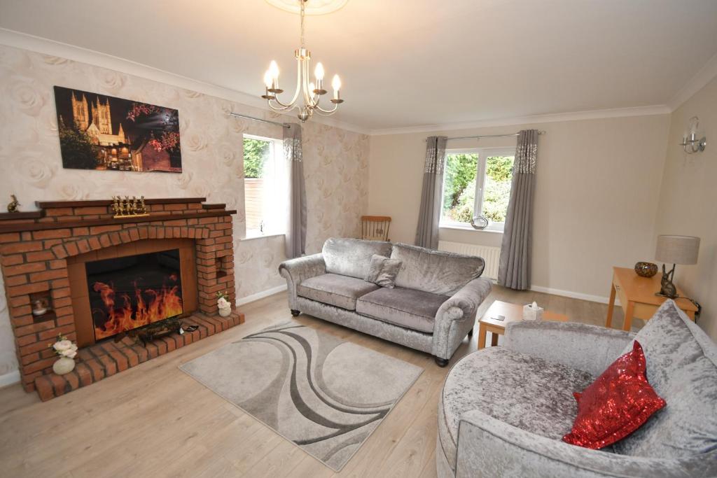 a living room with a couch and a fireplace at Hare Lodge in Woodhall Spa