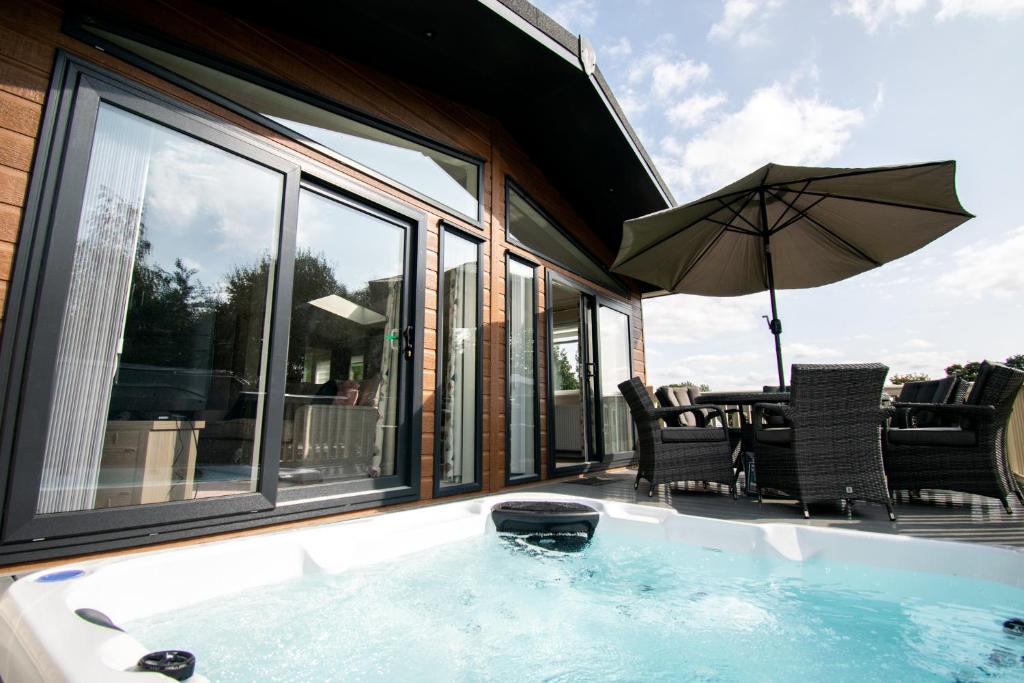 a hot tub with a table and chairs and an umbrella at The Crucible lodge with Hot Tub in York