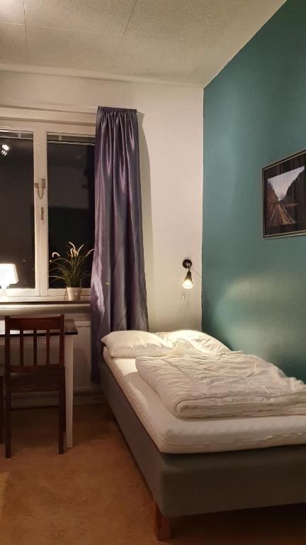 1 dormitorio con cama, ventana y mesa en Virserum Hostel, en Virserum