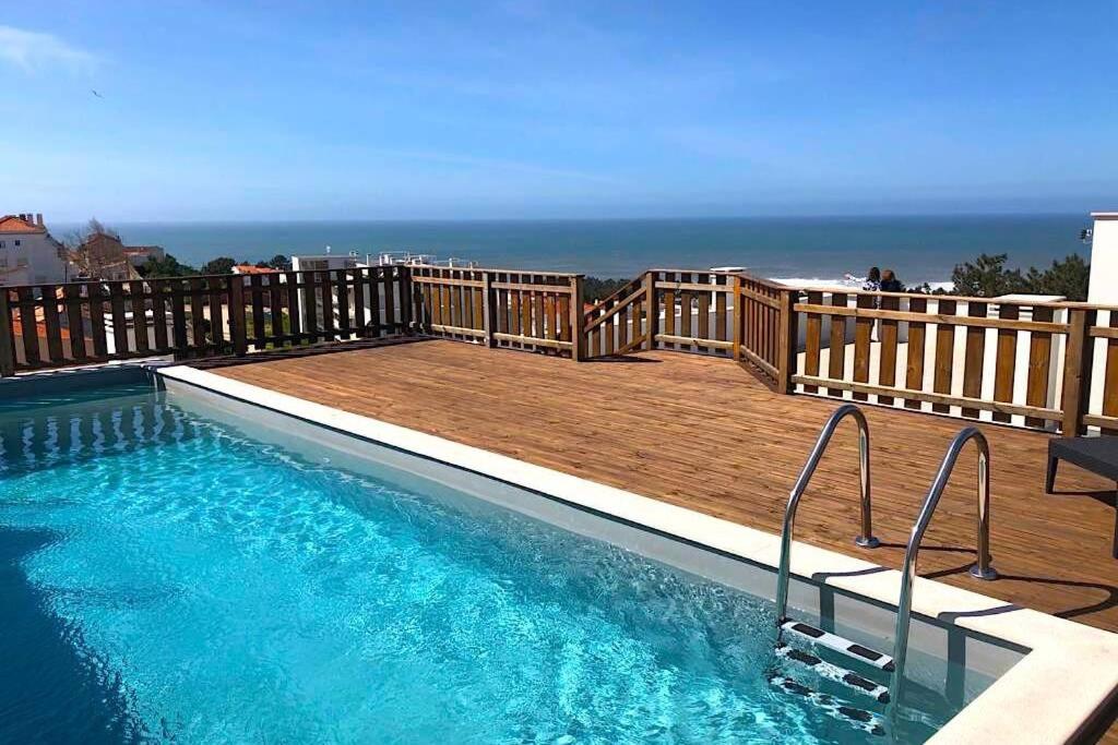 einen Pool auf einer Terrasse mit Meerblick im Hintergrund in der Unterkunft Terraços Do Mar - Rooftop Pool with Sea View in Nazaré